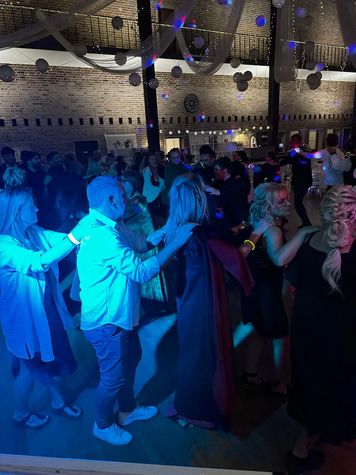 Feiernde Gäste im warmen Bühnenlicht